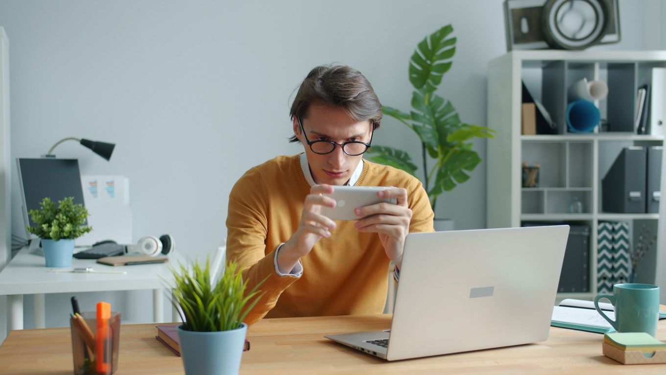 Man at a desk reading on his phone