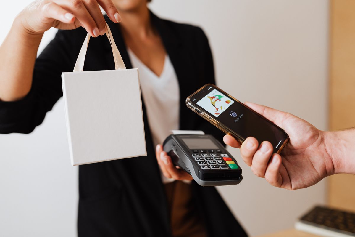 Person using a mobile phone to make a cashless payment