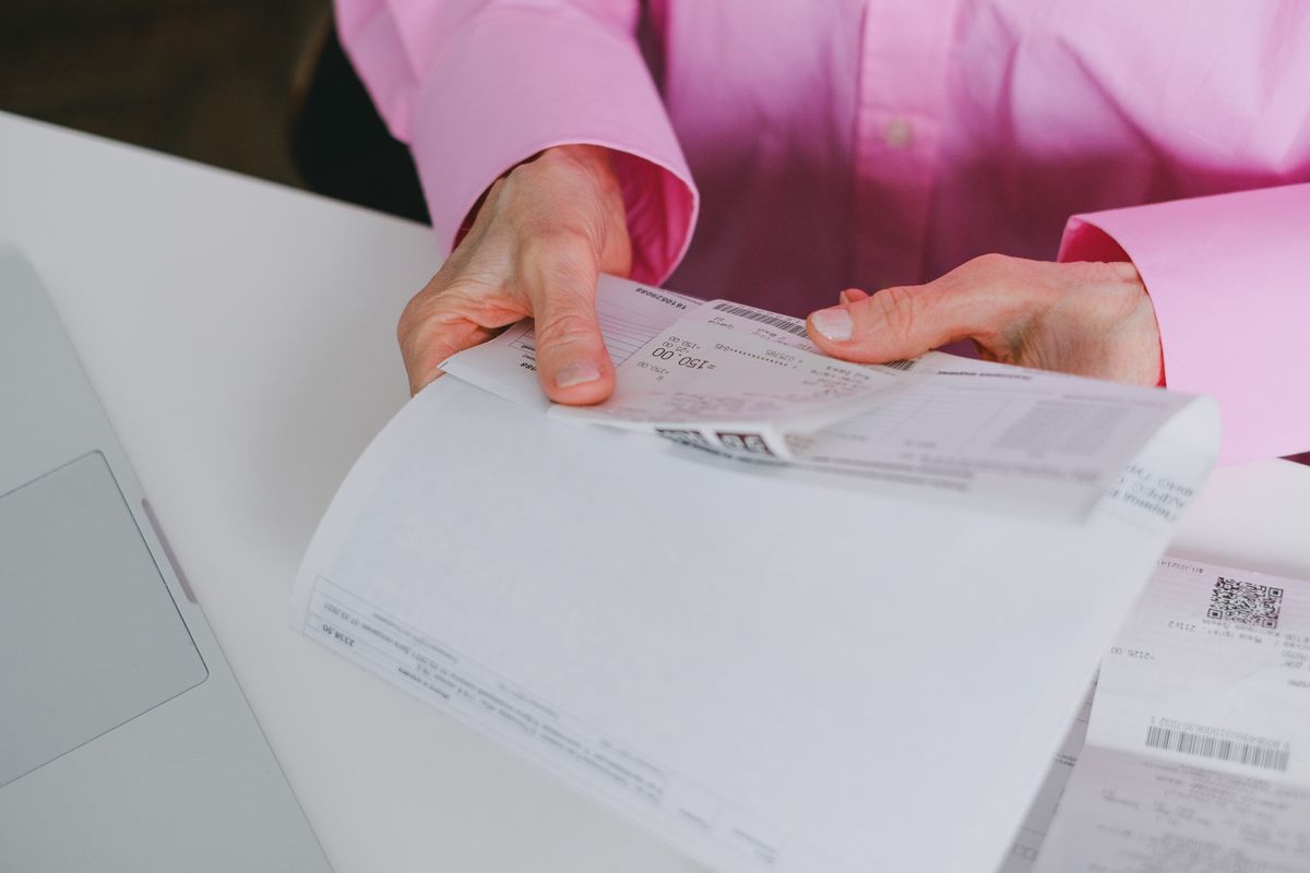 Business person reviewing paper receipts at a desk