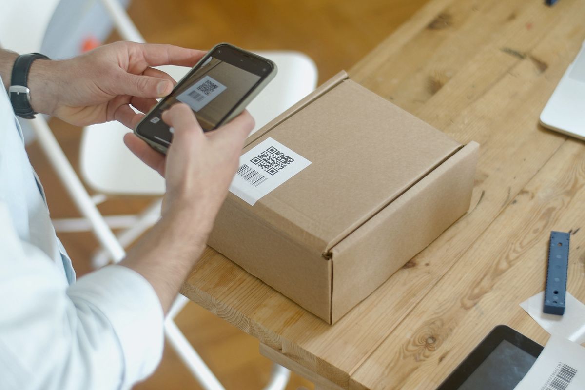 Person scanning a QR code on a product package with a smartphone
