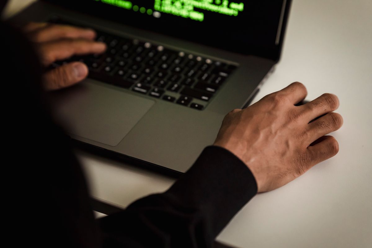 Overhead view of hands typing code on a laptop in a well-lit workspace