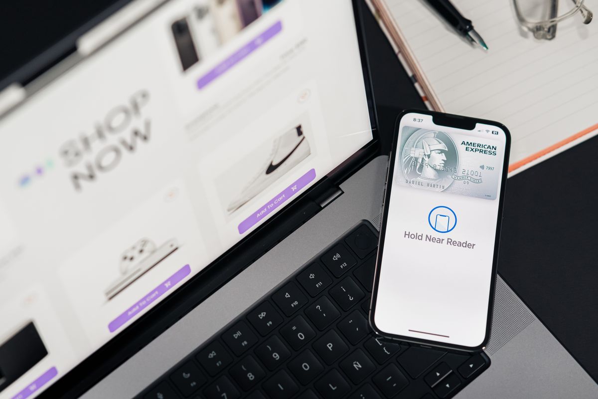 Online store checkout page open on a laptop next to a phone showing a card payment screen