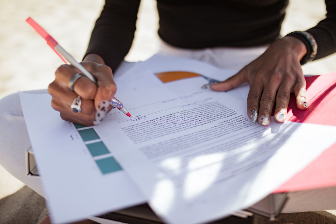 Person marking up a printed document with a red pen